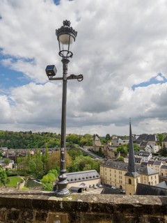 Urban landscape with modern elements, clouds in the sky and a historic lantern, Luxembourg City,