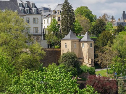 Historic buildings with towers, surrounded by green trees and a park. Springtime atmosphere,