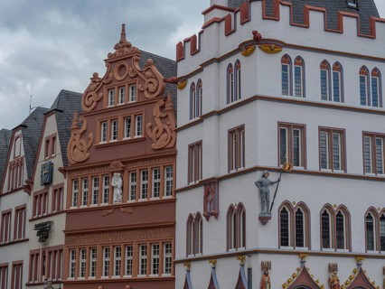 Row of historic buildings with detailed facades and Renaissance influences under a cloudy sky,