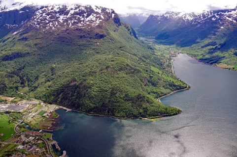 Breathtaking panorama of a fjord with snow-capped mountains and dense forests, view from Hoven,