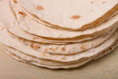 A stack of Mexican tortillas, on a gray table, top view, close-up, no people