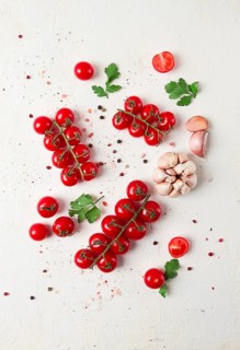Zweig mit Mini-Kirschtomaten, mit Gewürzen und Kräutern, Knoblauch, Lebensmittel Hintergrund,
