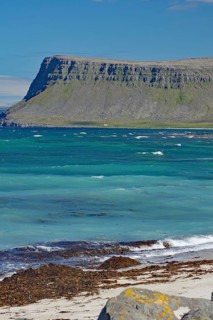 A rocky coastline with sharp-edged cliffs jutting out into the blue sea, Latrabjarg, Vestfirdir
