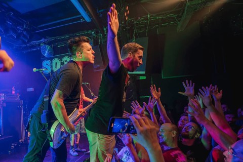 Chris Demakes, singer and guitarist of Less Thank Jake, and fan stage-diving live at Berlin SO36 on