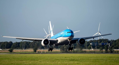 KLM aircraft landing at Amsterdam Schiphol Airport, Polderbaan, 18R/36L, wind farm in the