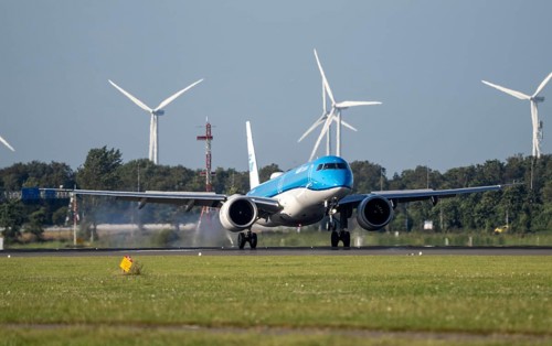 KLM aircraft landing at Amsterdam Schiphol Airport, Polderbaan, 18R/36L, wind farm in the