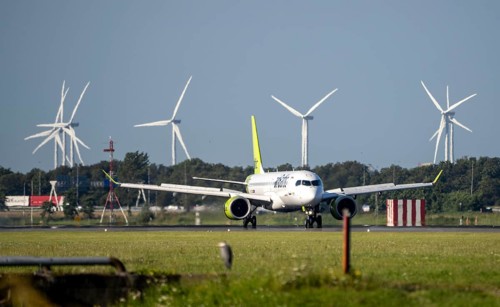 Air Baltic aircraft landing at Amsterdam Schiphol Airport, Polderbaan, 18R/36L, wind farm in the