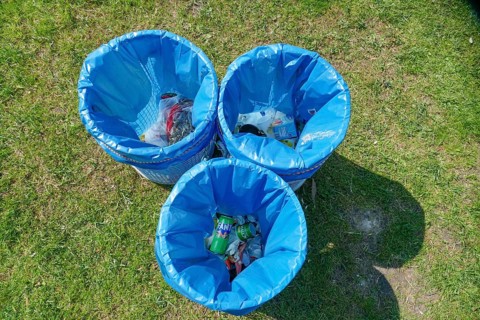 Rubbish bins with blue bin liners standing in a meadow, top view, Germany, Europe