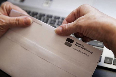 An elderly woman opens a letter from Deutsche Rentenversicherung. Berlin, 05.08.2024