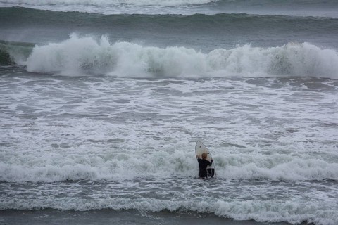 A surfer enters the water on an ideal day for surfing along the Wild Atlantic Way. Strandhill,