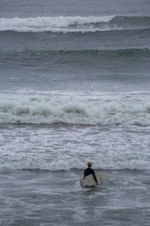 A surfer enters the water on an ideal day for surfing along the Wild Atlantic Way. Strandhill,