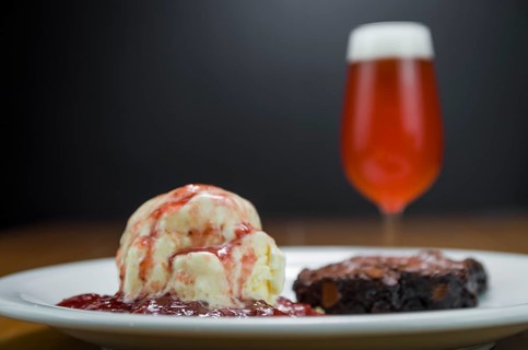 Close-up of delicious chocolade brownie dessert with cream ice cream and raspberry beer