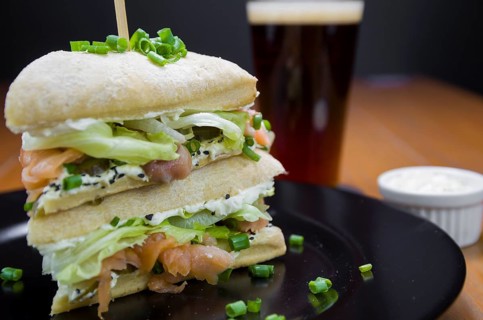 Delicious salmon sandwich close-up and glass of beer