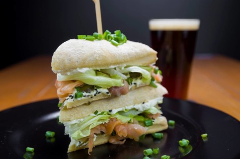 Delicious salmon sandwich close-up and glass of beer