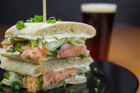 Delicious salmon sandwich close-up and glass of beer