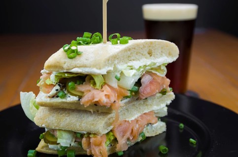 Delicious salmon sandwich close-up and glass of beer