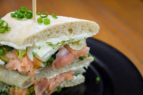 Delicious salmon sandwich close-up and glass of beer