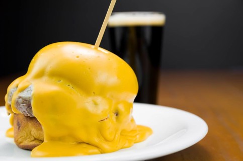 Delicious close-up of hamburger covered in cheddar cheese sauce