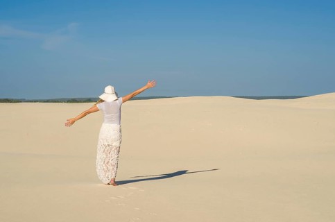 Young woman walking in the dunes, desert