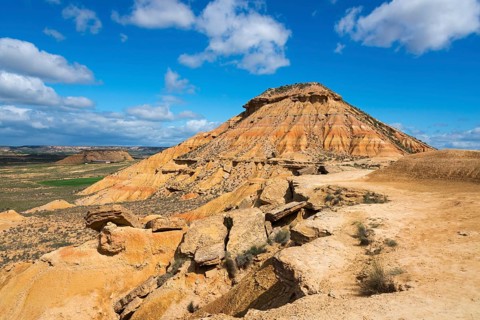 Large hill with stony structure in a desert-like landscape under a blue sky, Bardenas Reales