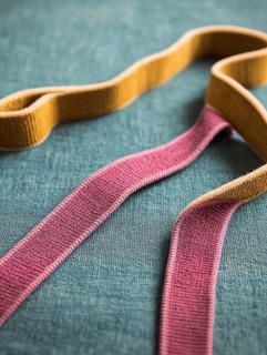 Close-up of pink and yellow ribbons on a green background, AI generated
