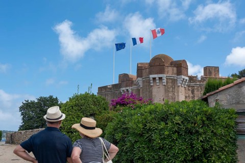 Two tourists stand in front of the citadel of Saint-Tropez, built in 1602 as a defence against the