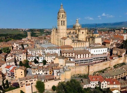 A city view with an imposing cathedral in the centre, surrounded by historic buildings on a hill,