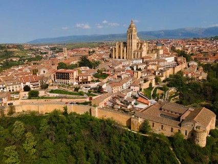 View of a historic city with an imposing church in the centre and many buildings on a hill, aerial