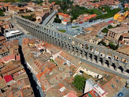 Aerial view of a city crossed by an impressive aqueduct, surrounded by historic buildings, Aerial