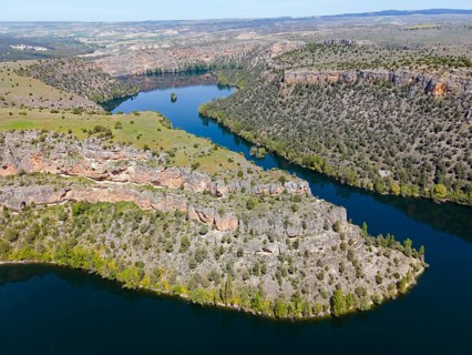 Expansive view of a river winding through deep gorges and a mountainous landscape, aerial view,