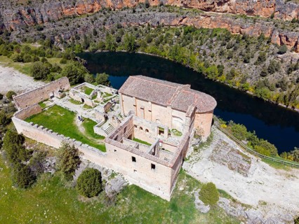 Historic ruin in a rocky landscape with river and lush vegetation, bird's eye view, aerial view,