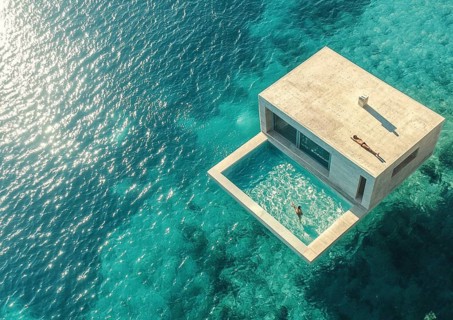 Luxurious modern villa with a floating pool, surrounded by crystal clear turquoise waters and a