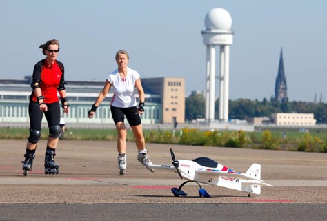 Berlin, 12.10.09 2010, Rollerbladers drive past a model aeroplane on the runway of the former