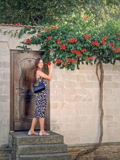 Young woman enjoys a beautiful summer day in vacation standing at the threshold of a door smelling