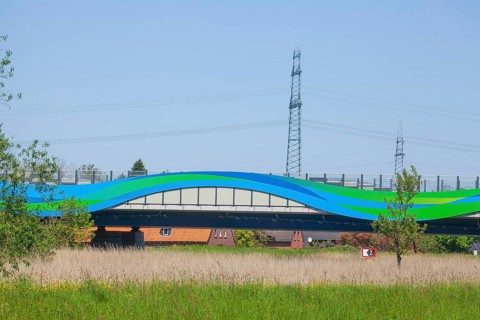 Colourfully painted motorway bridge with noise barrier over the river Este, Buxtehude, Altes Land,