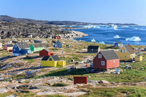 Typical Greenlandic houses, Inuit settlement in front of icebergs, Qeqertaq, Disko Bay, West