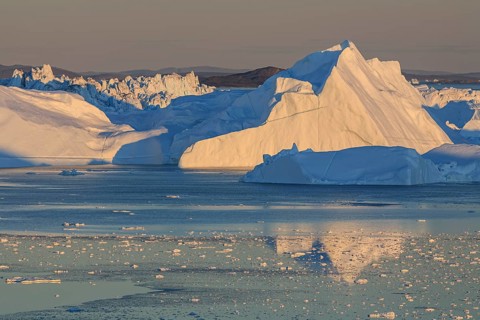 Icebergs reflected in fjord, midnight sun, summer, Ilulissat Icefjord, Disko Bay, West Greenland,