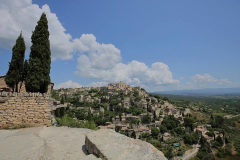 View of townscape with cypresses and rocks, mountain village, Gordes, Luberon, Vaucluse, Provence,