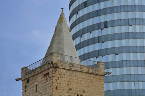 Spire of the historic Johannistor and glass window of the modern Jentower, glass wall, city gate,