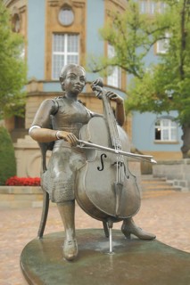 Musicians' fountain with cello player by Bonifatius Stirnberg 1989 in front of the blue town hall,
