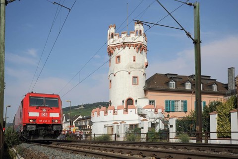Gothic eagle tower with train with tracks, view from below, railway traffic, locomotive, overhead