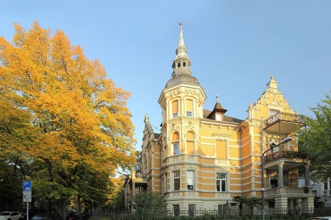 Historicist villa built in 1897 with corner turrets and decorations, tree, autumn atmosphere,