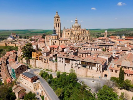 Panorama of a medieval city with a large church surrounded by historic buildings and nature under a