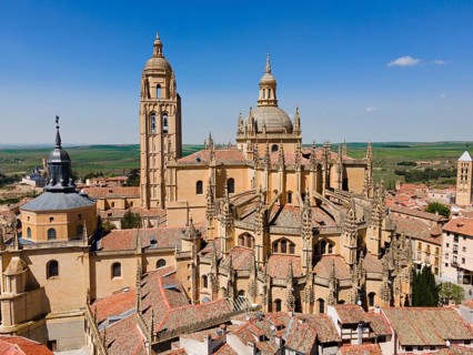 Historic church with Gothic and Renaissance elements surrounded by a medieval town under a clear