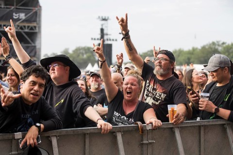 Festival visitors give the devil's salute at the Wacken Open Air in Wacken. The traditional metal