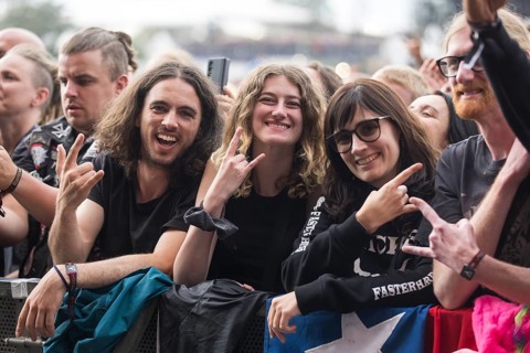 Festival visitors give the devil's salute at the Wacken Open Air in Wacken. The traditional metal