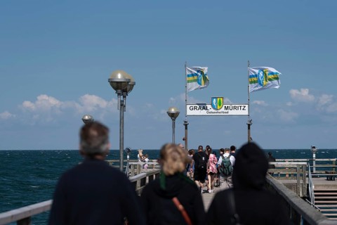 Holidaymakers on the pier, flags in the background, Graal-Müritz, Mecklenburg-Vorpommern, Germany,
