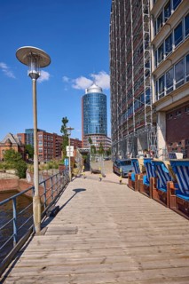 Wooden jetty with lantern and beach chairs, Hanseatic Trade Centre with scaffolding and Columbus