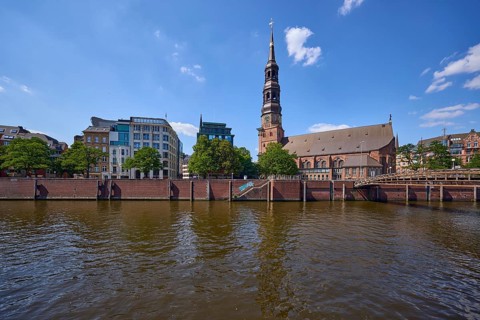 Customs canal with main church St. Katharinen against blue sky with cumulus clouds, Speicherstadt,