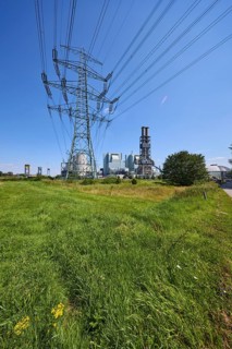 Moorburg coal-fired power station with high-voltage pylon against a cloudless blue sky in the